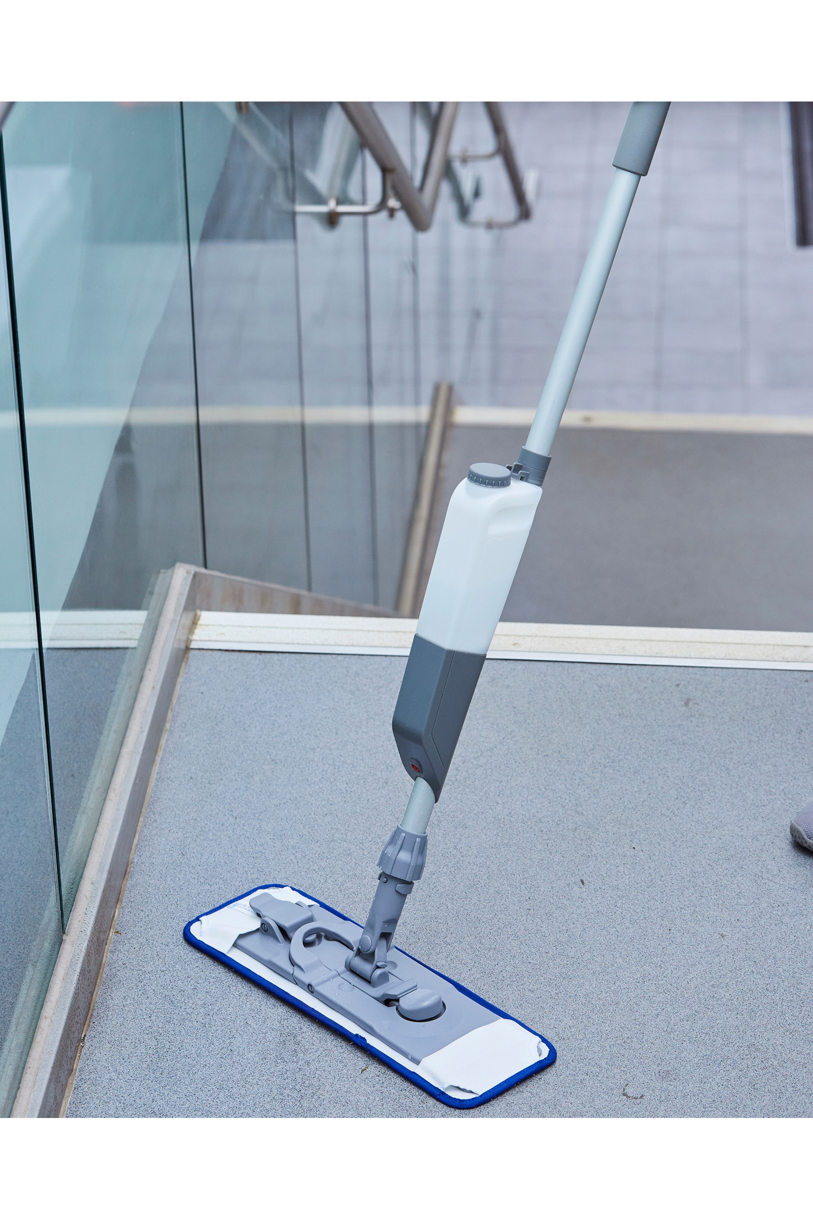 Pro-mist Microfibre Antibacterial Mop Kit cleaning floor with ergonomic spray handle.